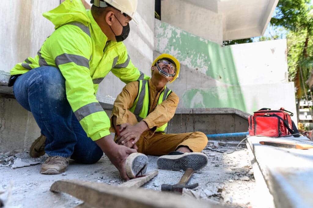 Builder worker has an accident at work. His feet stepped on nail