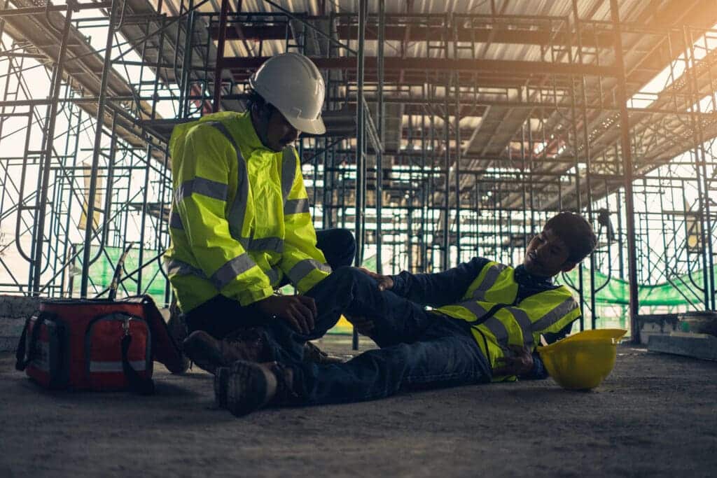 Man assisting injured construction worker